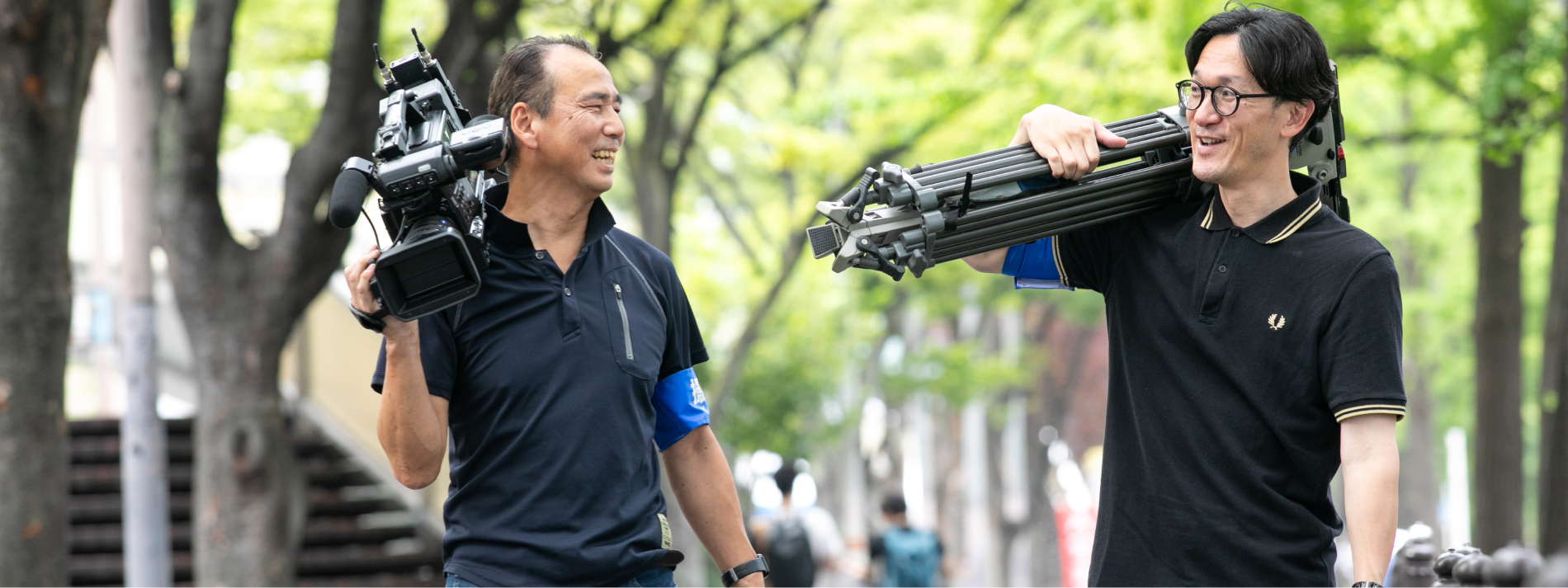 カメラマン2人が機材を運んでいる様子